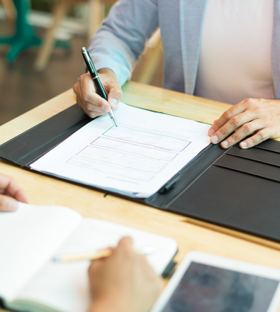 close-up-businessman-sitting-table-filling-document 1